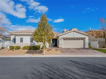 Single-story home with tan siding, neutral colored garage door, and well-manicured landscaping at 3020 Via Venezia, Henderson, NV 89052