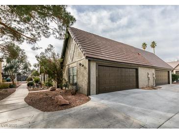 Exterior view of a brown double garage with a paved driveway and walkway at 3988 Salisbury Pl, Las Vegas, NV 89121