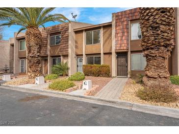 Updated townhome exterior with attractive landscaping and a paved walkway at 4182 Mississippi Ave, Las Vegas, NV 89103