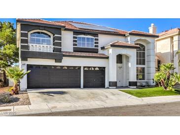 Two-story house with dark gray and white exterior, two-car garage, and landscaped front yard at 8509 Copper Falls Ave, Las Vegas, NV 89129