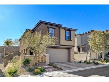 Contemporary two-story home with a two car garage, mature landscaping, and brick stairs leading to the front door at 889 Ariel Heights Ave, Las Vegas, NV 89138