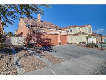 Two-car garage with driveway and landscaping; view of a house's exterior at 9008 Rusty Rifle Ave, Las Vegas, NV 89143