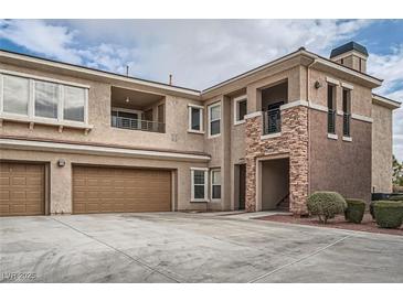 Tan two-story building with attached garages and landscaping at 10809 Garden Mist Dr # 2093, Las Vegas, NV 89135