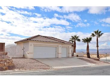 Two-car garage, desert landscaping, and a two-story home with a tile roof at 53 Flowering Desert Dr, Palm Gardens, NV 89039