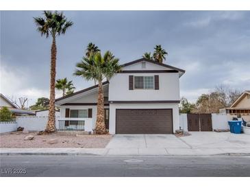 Two-story house with brown garage door and palm trees at 881 Stonehenge St, Las Vegas, NV 89110