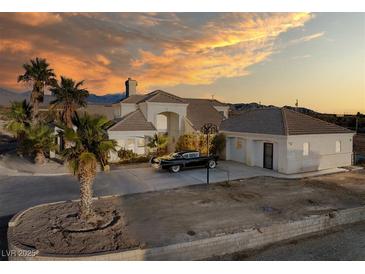 Two-story house with a large yard, palm trees, and mountain views at 1411 E Blosser Ranch Rd, Pahrump, NV 89060