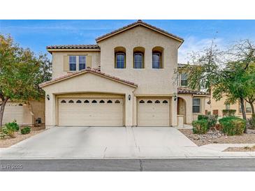 Two-story house with beige exterior, three-car garage, and landscaping at 221 Raptors View Ave, North Las Vegas, NV 89031