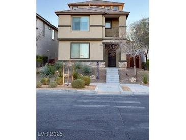 Two-story home with a tidy front yard, landscaped bushes, and a pedestrian crossing in the foreground at 3041 Savella Ave, Henderson, NV 89044