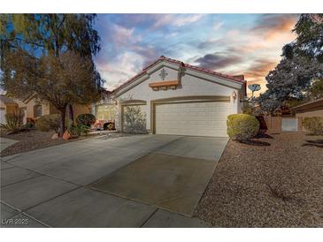 Two-car garage and attractive landscaping at dusk at 4176 Demoline Cir, Las Vegas, NV 89141