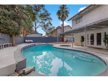 Backyard pool area with mature landscaping and patio with outdoor seating, perfect for relaxing and entertaining at 4330 Flandes St, Las Vegas, NV 89121