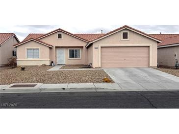 Single-story home featuring desert landscaping, a red tiled roof, and an attached two-car garage at 4618 Zia Ridge St, North Las Vegas, NV 89031