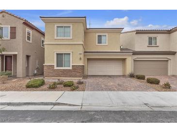 Two-story house with beige exterior, two-car garage, and landscaped front yard at 5233 Fiery Sky Ridge St, Las Vegas, NV 89148