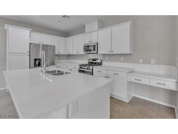 A modern kitchen featuring white cabinetry, stainless steel appliances and solid surface countertops at 5233 Fiery Sky Ridge St, Las Vegas, NV 89148