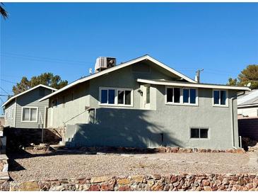 Gray house with a smaller building in the back, and a gravel yard at 624 D Ave, Boulder City, NV 89005