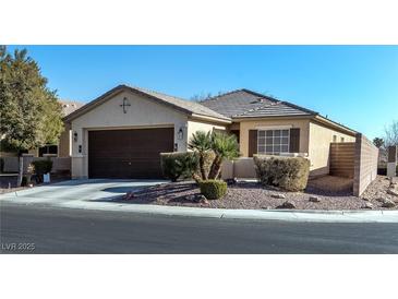 Single-story house with brown garage door and landscaped front yard at 6420 Birdcall St, North Las Vegas, NV 89084