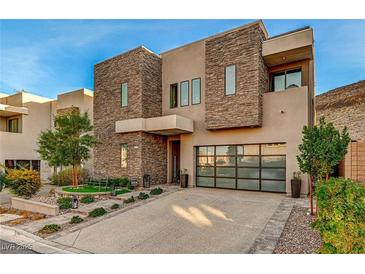 Modern two-story home with stone accents and a glass garage door at 821 Barrhead Ave, Henderson, NV 89012