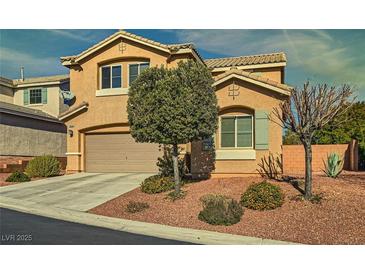 Two-story house with beige exterior, landscaping, and a two-car garage at 10260 Danskin Dr, Las Vegas, NV 89166