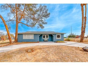 Ranch style home with blue exterior, landscaping, and long driveway at 1620 Leonard Ln, Las Vegas, NV 89108