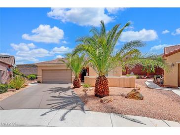 Single-story home with desert landscaping, two palm trees, and a two-car garage at 2090 Lewiston Pl, Henderson, NV 89044