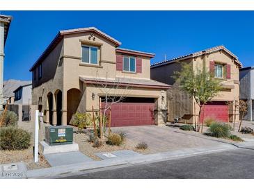 Two-story stucco home with a red garage door and desert landscaping provides curb appeal at 3812 Seyfert Ave, North Las Vegas, NV 89084