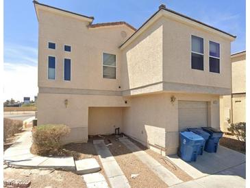 Tan two-story house with attached garage and driveway at 6117 Daisy Lee Ave, Las Vegas, NV 89108