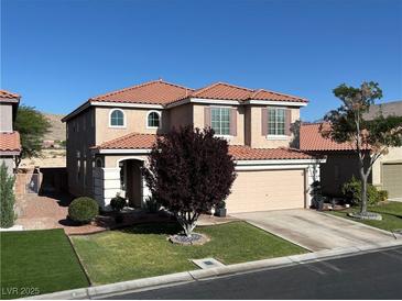 Charming two-story home with a well-manicured lawn and a beautiful tree in the front yard at 5859 Noble Stand St, Las Vegas, NV 89148