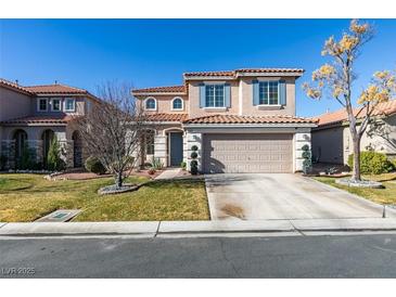 Two-story house with attached garage and landscaped front yard at 5859 Noble Stand St, Las Vegas, NV 89148