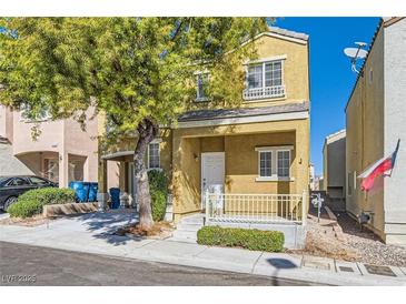 Two-story tan house with a small porch, white railing, and a mature tree in the front yard at 9140 Silk Threads Ave, Las Vegas, NV 89149