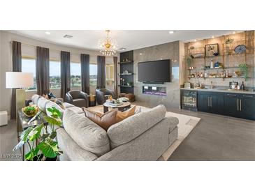 Bright living room with modern furniture, bar, large windows, and an electric fireplace at 9145 Las Manaitas Ave # 401, Las Vegas, NV 89144