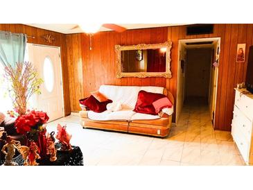 Cozy living room features wood paneling, a large mirror and a comfortable sofa at 4130 Balboa Ave, Las Vegas, NV 89121