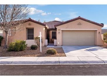 Single-story house with tan exterior, tile roof, and two-car garage at 2595 Fountain Ave, Pahrump, NV 89048