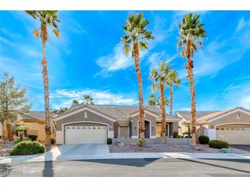 Charming single-story home featuring mature palm trees, a well-maintained lawn, and a two-car garage at 471 Eagle Vista Dr, Henderson, NV 89012