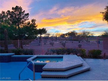 Inviting backyard with beautiful pool, spa, and colorful sunset views at 471 Eagle Vista Dr, Henderson, NV 89012