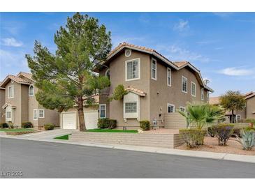 Two-story townhome with attractive landscaping and a two-car garage at 9330 Golden Timber Ln, Las Vegas, NV 89117