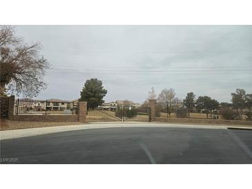 Gated community entrance with brick pillars, black iron fence, and landscaped common areas, providing security and curb appeal at 217 Via Luna Rosa Ct, Henderson, NV 89011