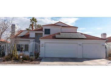 Two-story home with a tile roof, two-car garage, and mature landscaping at 3008 Blue Fin Cir, Las Vegas, NV 89128