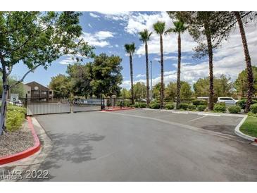 Gated entrance to community with palm trees and parking at 5006 S Rainbow Blvd # 103, Las Vegas, NV 89118