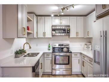 Updated kitchen features white cabinets, gold hardware, and quartz countertops at 5101 Village Dr, Las Vegas, NV 89142