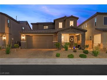 Charming two-story home featuring a well-manicured front yard and an attached two-car garage at 7073 Range Valley St, North Las Vegas, NV 89084