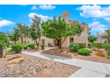 Attractive condo building exterior with landscaping and walkway at 7900 Idledale Ct # 102, Las Vegas, NV 89145