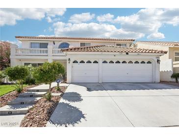 Two-story house with a three-car garage and landscaped front yard at 9123 Claretta Dr, Las Vegas, NV 89129