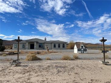 Single-story house with a large front yard and desert landscape at 1400 Equestrian Ct, Pahrump, NV 89048