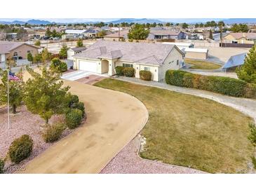 Single-story house with a large yard, long driveway, and detached garage at 1920 Cavalry St, Pahrump, NV 89048