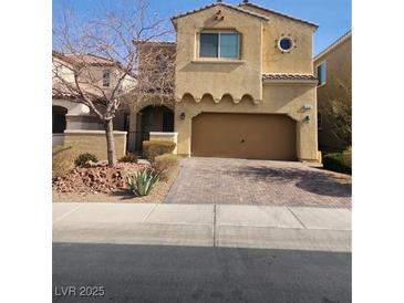 Two-story house with tan exterior, two-car garage, and landscaped yard at 1112 Via San Pietro, Henderson, NV 89011