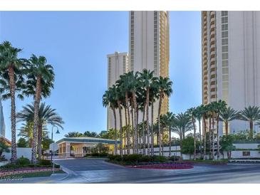 Luxury high-rise building with palm trees and gated entrance at 135 E Harmon Ave # 718, Las Vegas, NV 89109