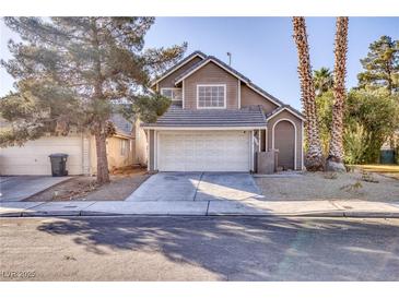 Two-story house with attached garage and landscaping at 1702 La Cruz Dr, Henderson, NV 89014