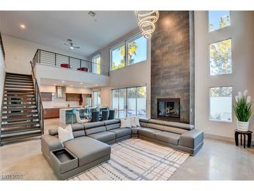 Spacious living room featuring a modern fireplace, high ceilings, and a large comfortable sectional sofa at 2680 Mystere Ct, Las Vegas, NV 89117