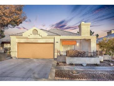 Single-story house with attached garage, landscaping, and a neutral color palette at 348 Wild Plum Ln, Las Vegas, NV 89107