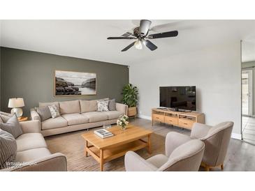 Bright living room featuring comfortable seating and a large TV at 3701 Guinevere Ave, Las Vegas, NV 89110