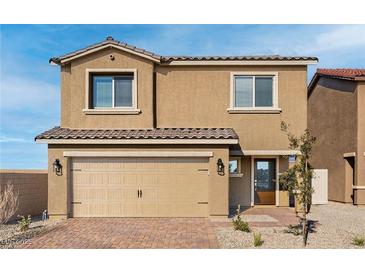 Two-story house with tan exterior, two-car garage, and landscaped front yard at 4219 Gold Desert St, North Las Vegas, NV 89032